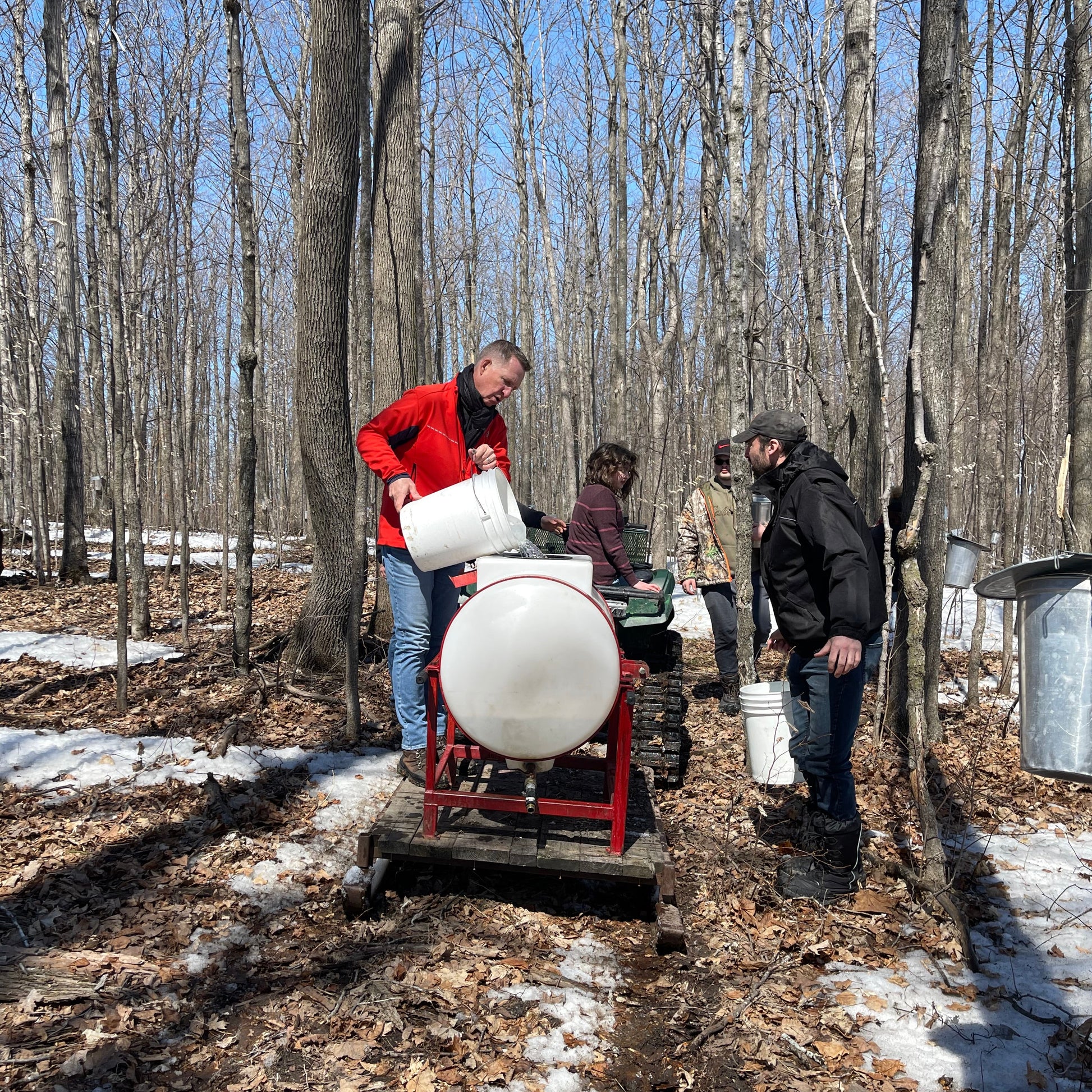 People working with a snowmobile in a snowy forest